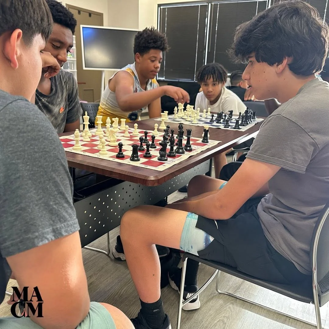 Young people playing chess together at a MACM program